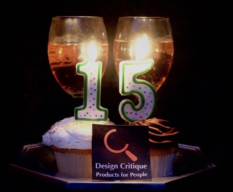 Photo of two cupcakes with the number 15 in candles on them, with two filled wine glasses behind.